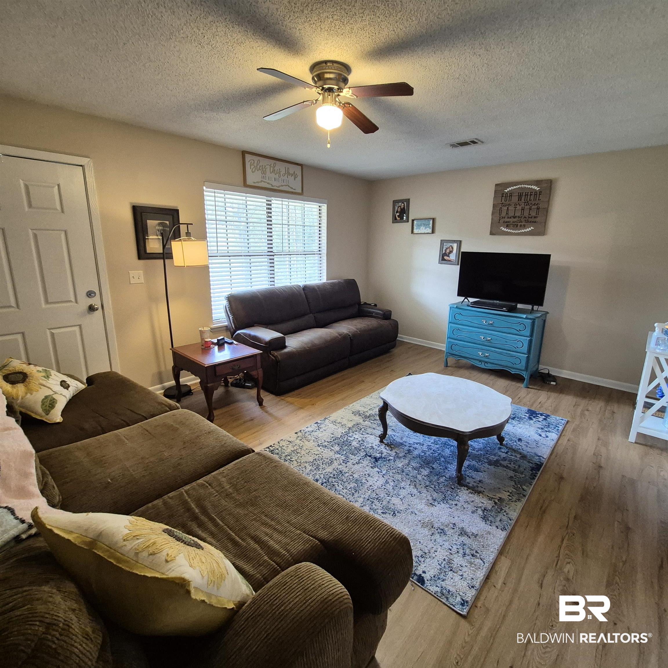 721 Perryman Street Evergreen, AL 36401 - Photo 5 of 26 Living room with wood finished floors, ceiling fan, and a textured ceiling