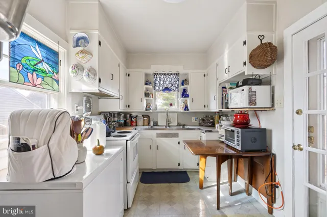 a room with furniture a flat screen tv and view kitchen