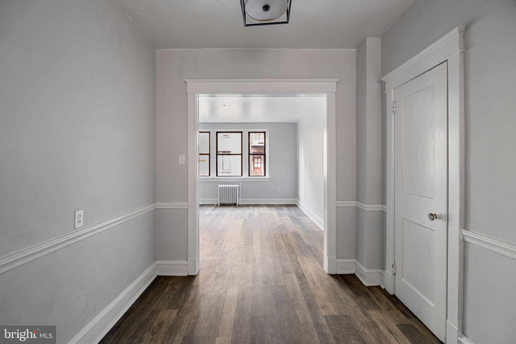 0 Garrett Road, Unit E201 Upper Darby, PA 19082 - Photo 12 of 19 wooden floor in an empty room with a window