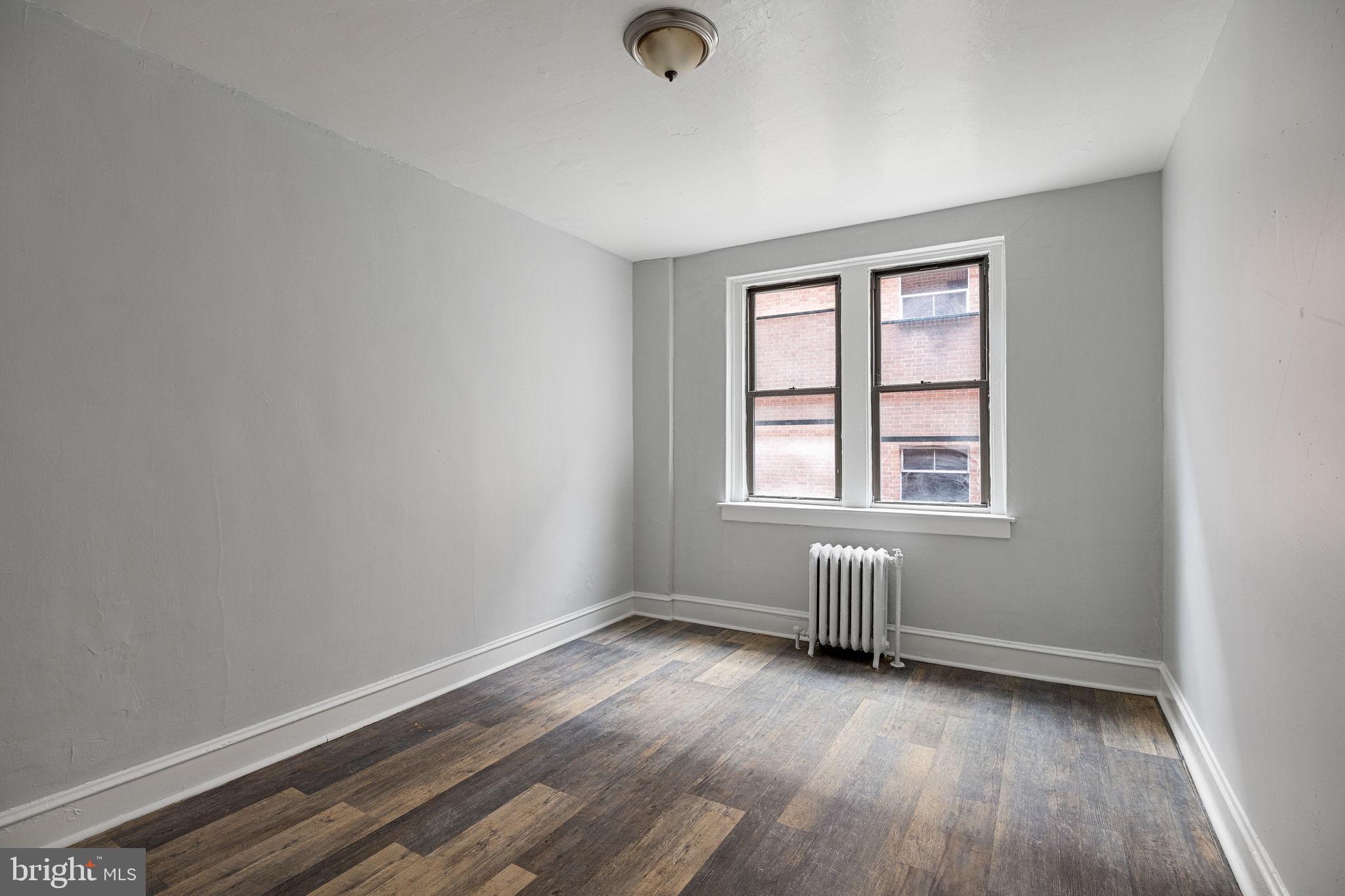 0 Garrett Road, Unit E201 Upper Darby, PA 19082 - Photo 13 of 19 an empty room with wooden floor and windows