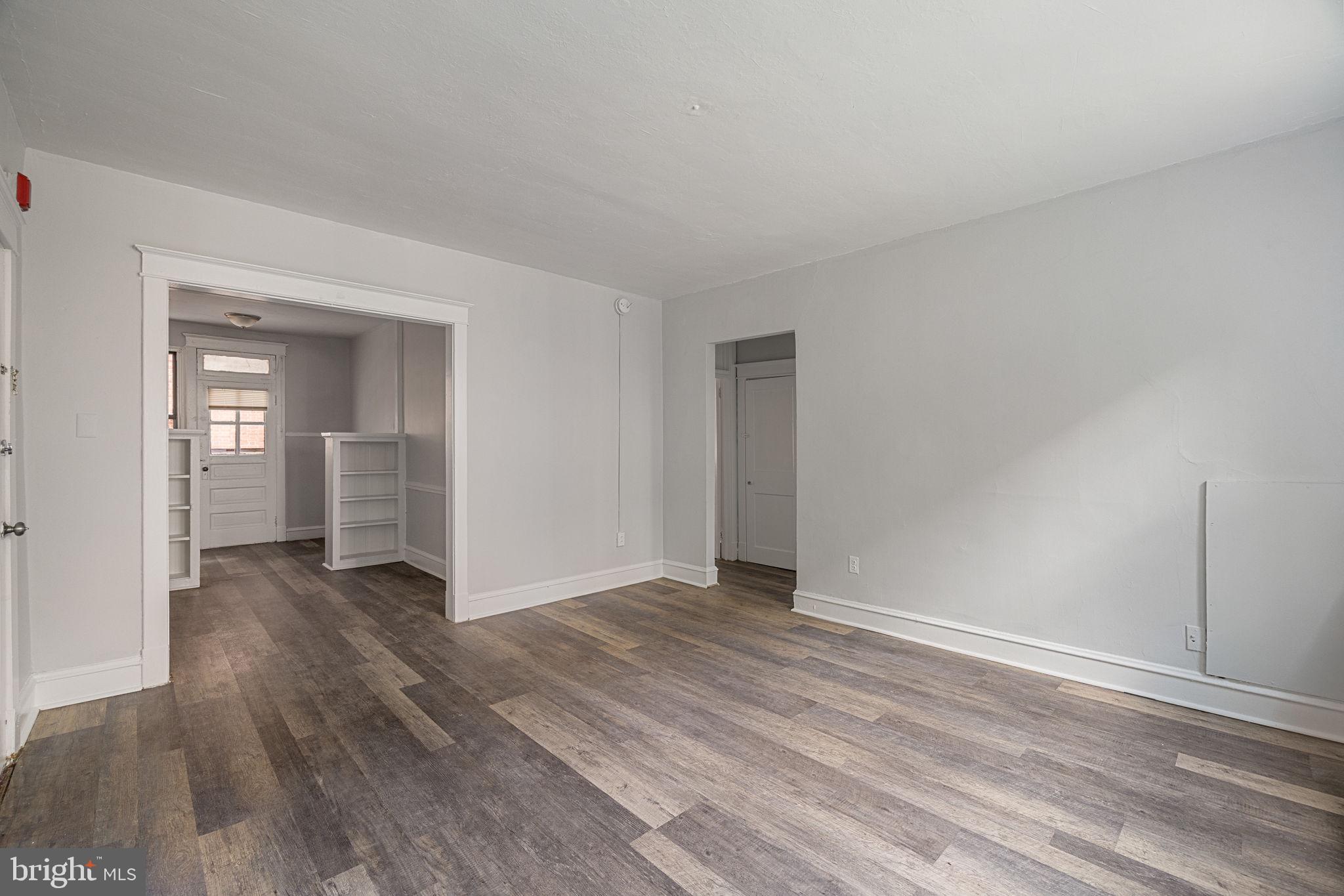 0 Garrett Road, Unit E201 Upper Darby, PA 19082 - Photo 9 of 19 a view of an empty room and window and wooden floor