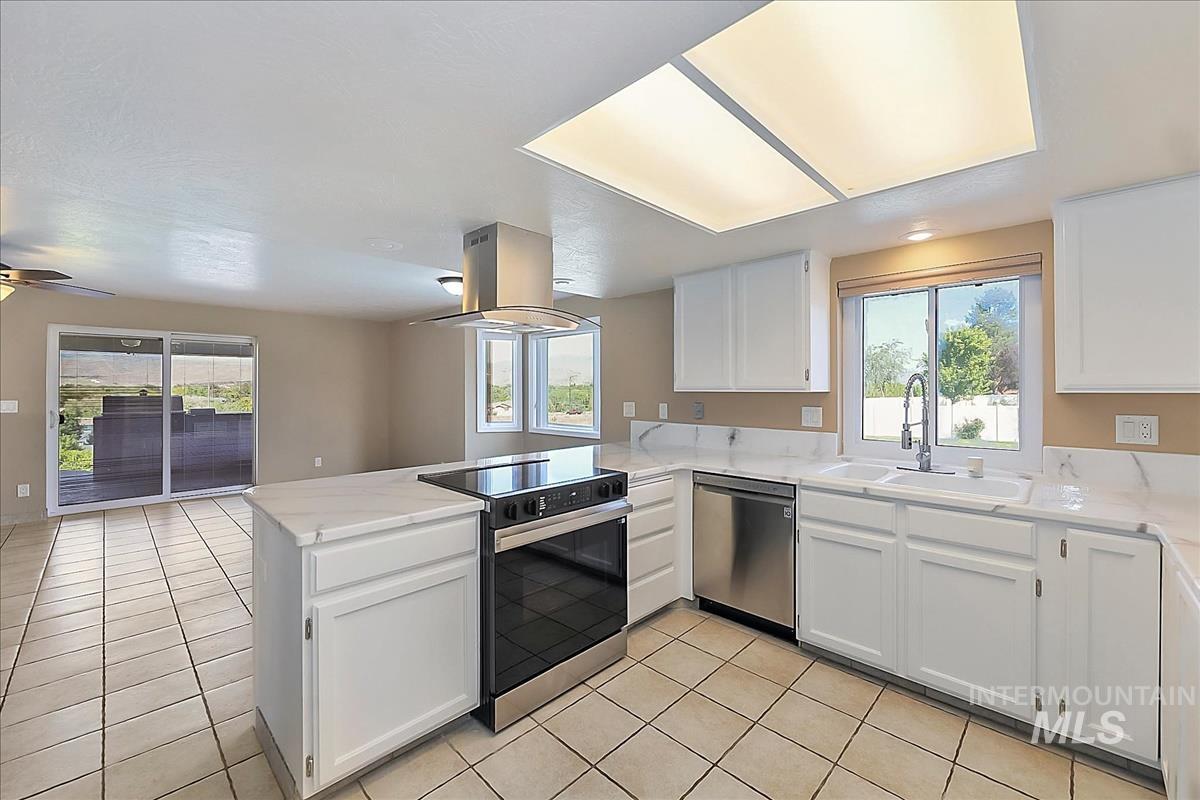 2804 West Sunrise Rim Road Boise, ID 83705 - Photo 8 of 50 Bright kitchen featuring white cabinetry and countertops, a stainless steel appliance suite, and ceramic tile flooring