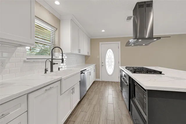 a view of a livingroom with a ceiling fan & windows
