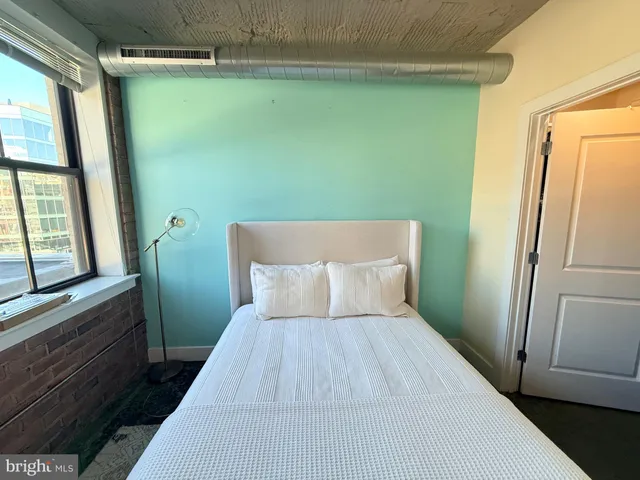 a bedroom with a bed and a painting on the wall