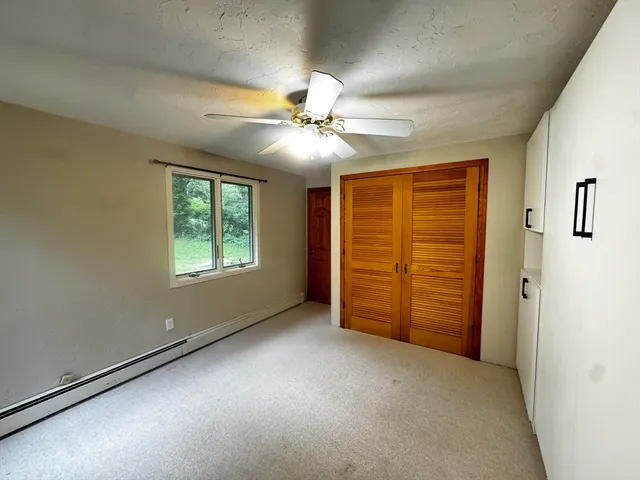 an empty room with windows and fan
