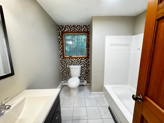 a bathroom with a sink a toilet and a mirror