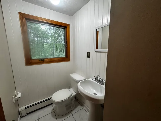 a bathroom with a toilet a sink and mirror