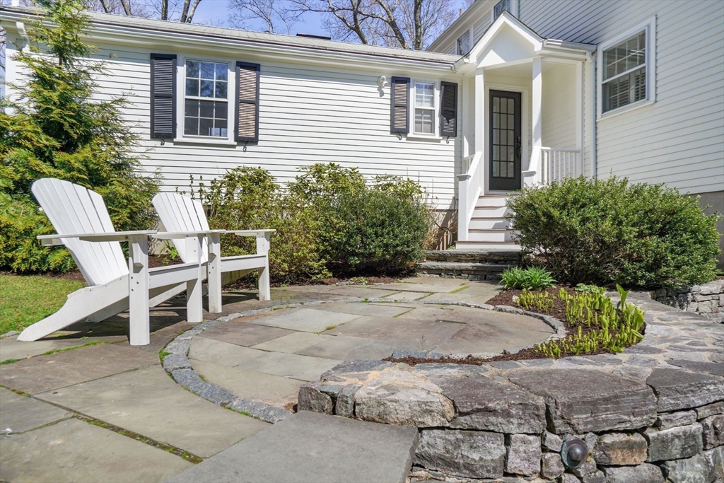 110 Hampshire Road Wellesley, MA 02481 - Photo 33 of 39 a white house with a large window and potted plants