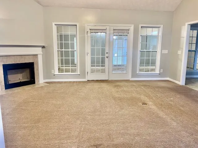 a view of an empty room with a fireplace and a window