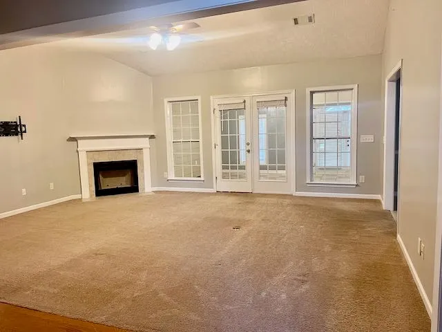 a view of an empty room with a fireplace and a window