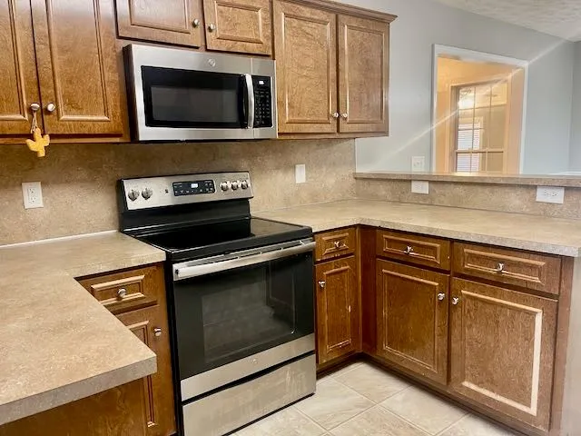 a kitchen with granite countertop cabinets stainless steel appliances and a sink
