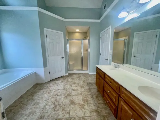 a spacious bathroom with a tub sink and mirror