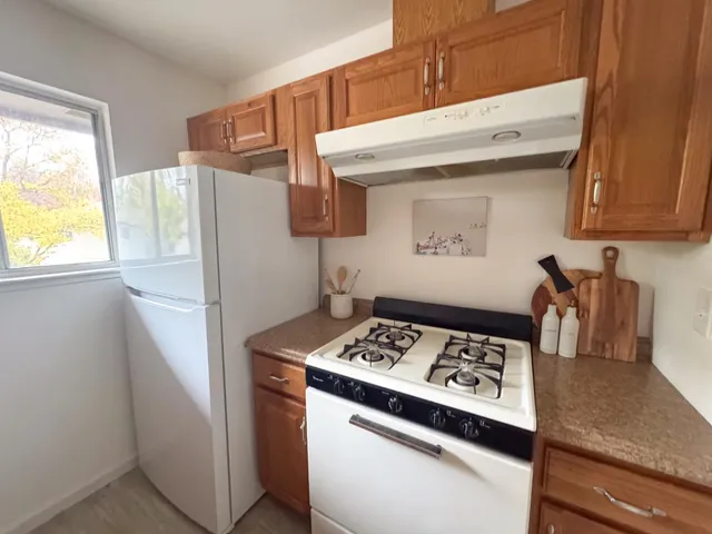 a kitchen with a refrigerator a stove a sink and a window
