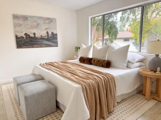 a bedroom with a large bed and a painting on the wall