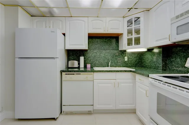 a kitchen with cabinets and white stainless steel appliances