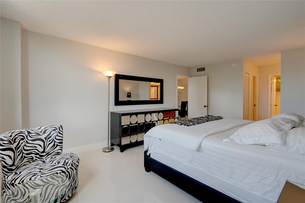 2000 South Ocean Boulevard, Unit 2L Lauderdale-by-the-Sea, FL 33062 - Photo 18 of 41 a bedroom with a bed and a flat screen tv