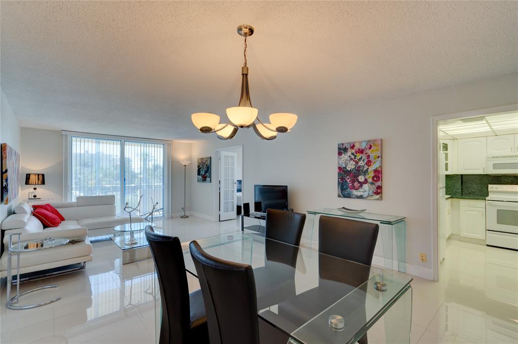 2000 South Ocean Boulevard, Unit 2L Lauderdale-by-the-Sea, FL 33062 - Photo 24 of 41 a dining room with furniture a flat screen tv and a large window