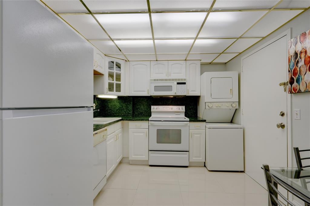 2000 South Ocean Boulevard, Unit 2L Lauderdale-by-the-Sea, FL 33062 - Photo 10 of 41 a kitchen with cabinets and white appliances