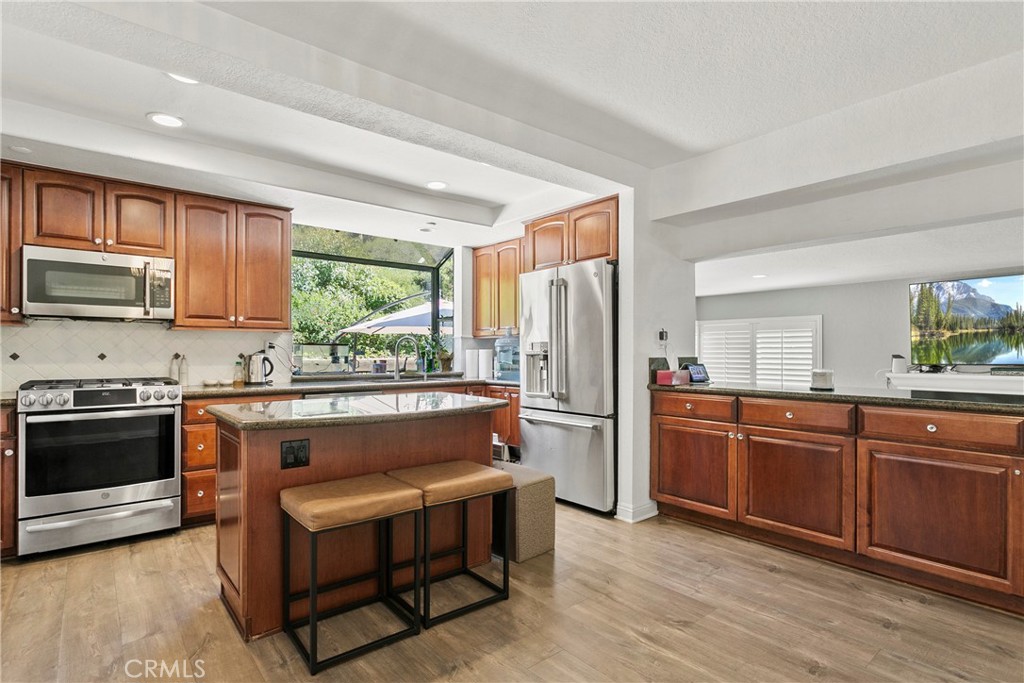 404 Calle Macho San Clemente, CA 92673 - Photo 10 of 19 a kitchen with stainless steel appliances granite countertop a refrigerator a stove a sink and dishwasher with wooden cabinets