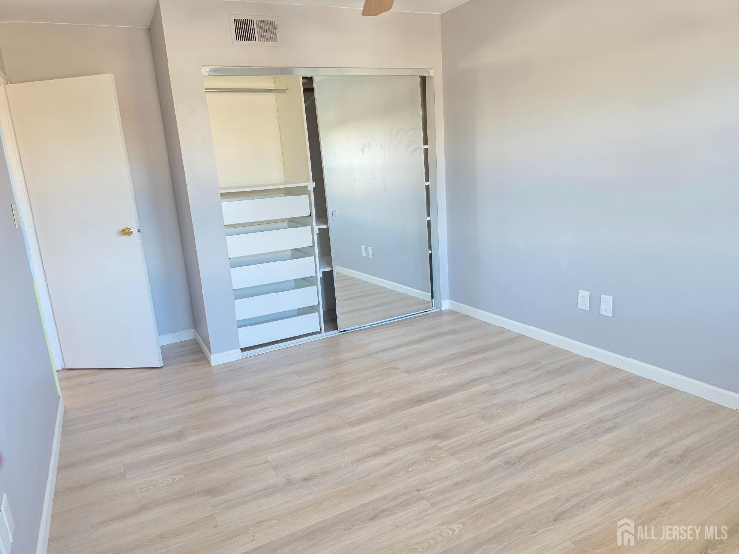 192 Evergreen Road, Unit 7B Edison, NJ 08837 - Photo 19 of 21 a view of an empty room with wooden floor and closet