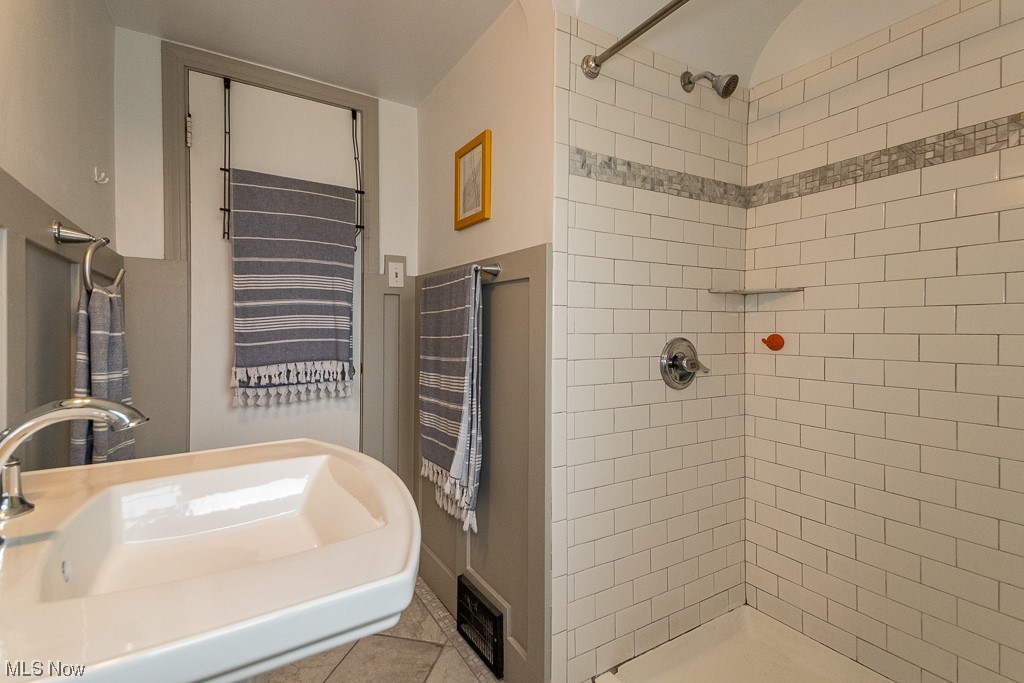 2419 Kingston Road Cleveland, OH 44118 - Photo 18 of 34 1st floor bathroom featuring washbasin, tiled shower, and light tile floors
