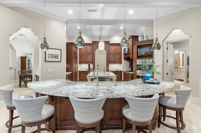 a bedroom with a large bed a chandelier and a book shelf