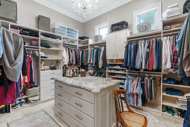 a bedroom with a large bed a chandelier and a book shelf