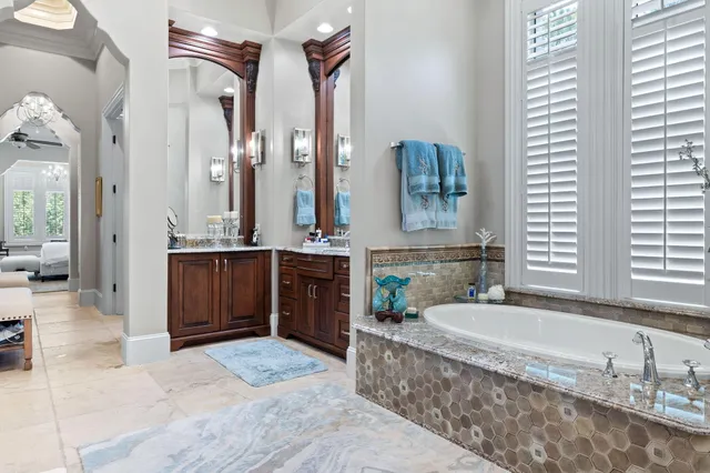 a bathroom with a granite countertop sink a toilet a mirror and shower