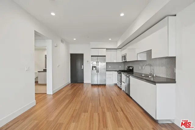 a kitchen with stainless steel appliances granite countertop a refrigerator and a stove top oven