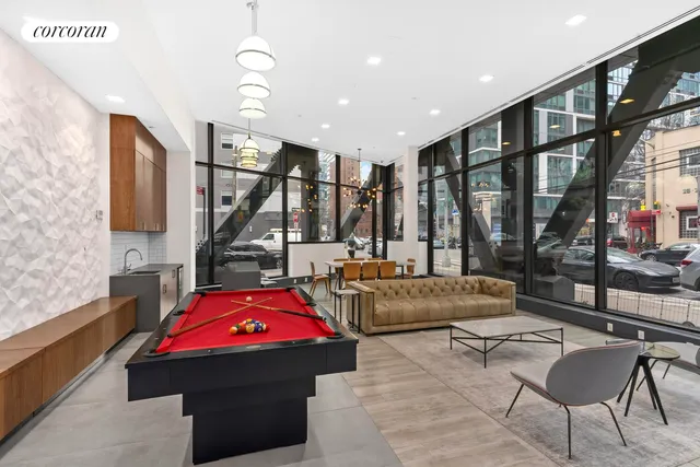 a room with gym equipment pool table and windows