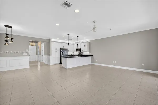 a large white kitchen with kitchen island a sink a stove and a refrigerator