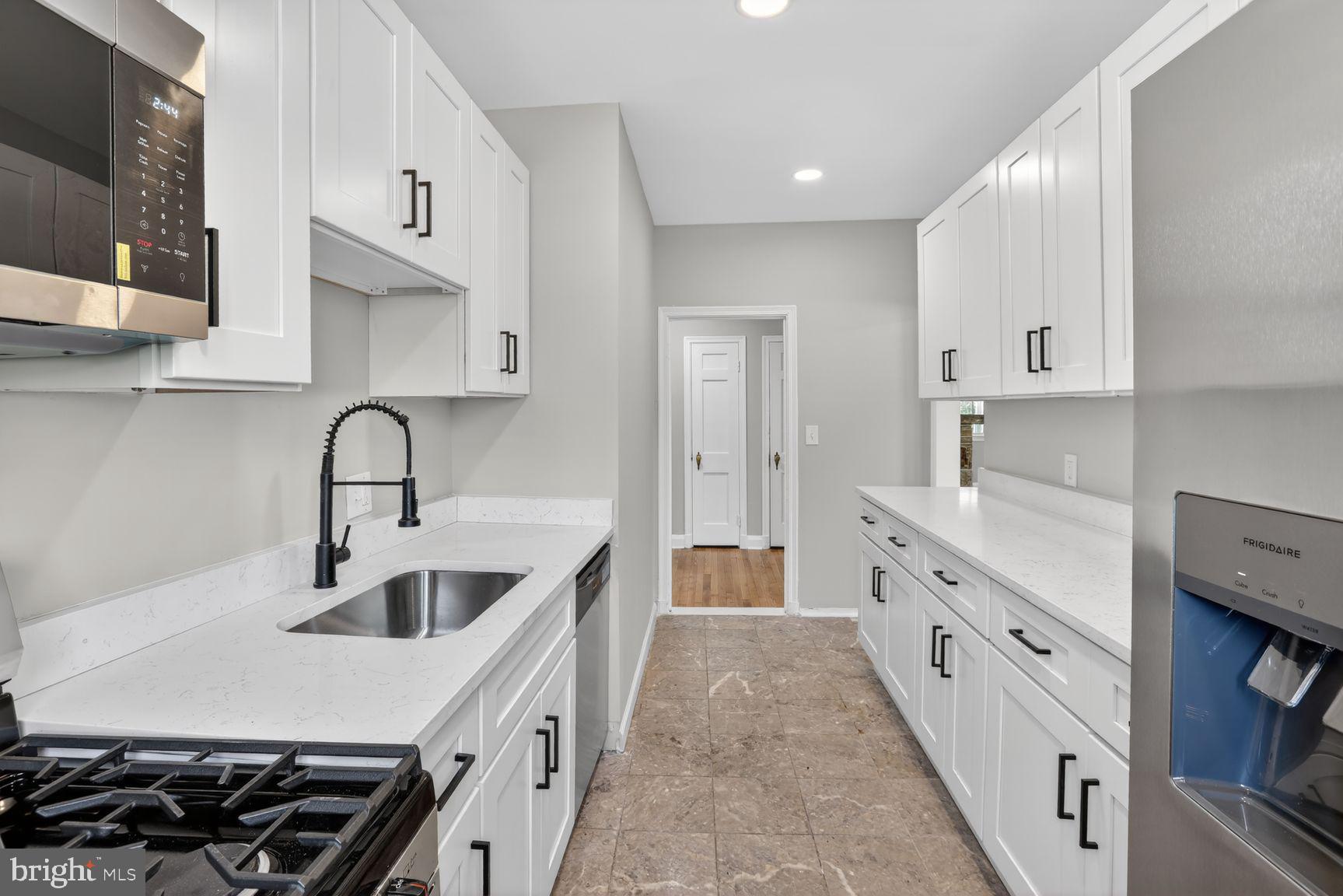 315 East Cold Spring Lane Baltimore, MD 21212 - Photo 2 of 25 a kitchen with white cabinets a sink and appliances