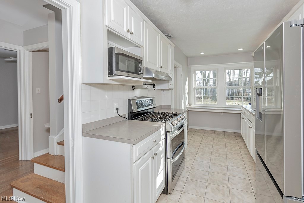 863 Roland Road Cleveland, OH 44124 - Photo 10 of 32 Kitchen with white cabinets, appliances with stainless steel finishes, plenty of storage.
