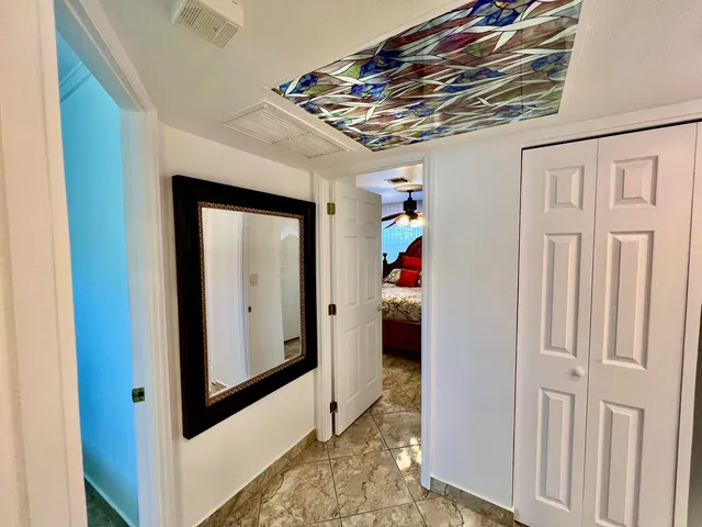 a view of a house with a big yard and potted plants and large trees