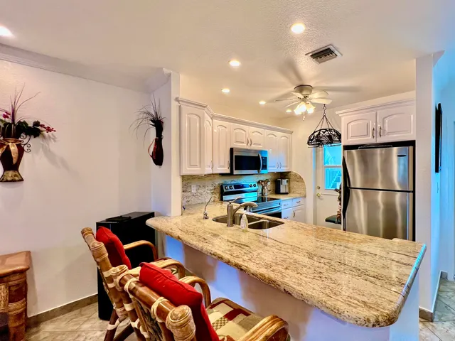 a kitchen with stainless steel appliances granite countertop a refrigerator and a sink