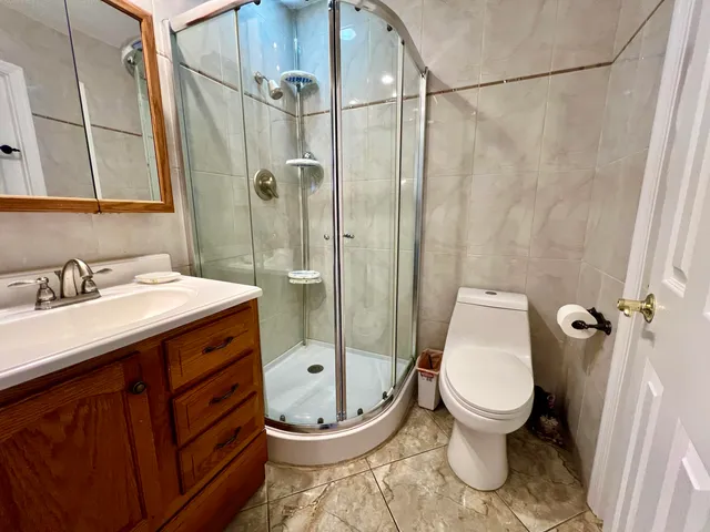 a bathroom with a granite countertop sink toilet a mirror and shower