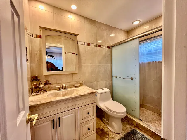 a kitchen with a sink a counter top space and living room view