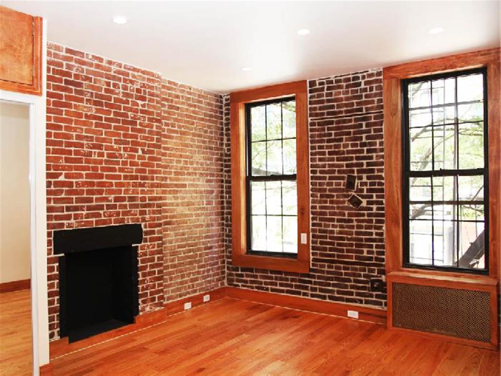 a view of an empty room with a fireplace and a window