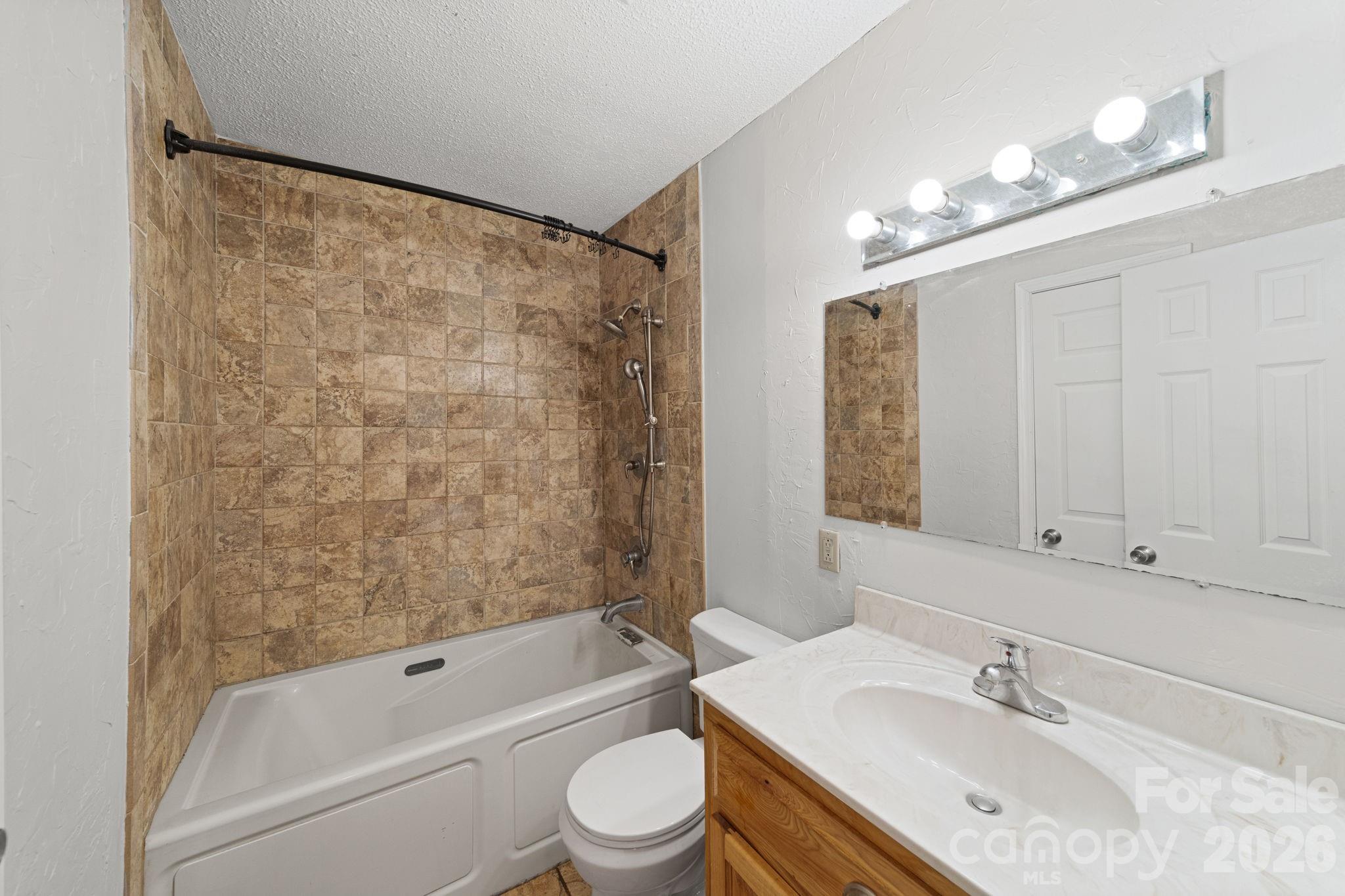 3227 Westover Road Statesville, NC 28677 - Photo 16 of 37 a bathroom with a granite countertop sink a toilet and shower