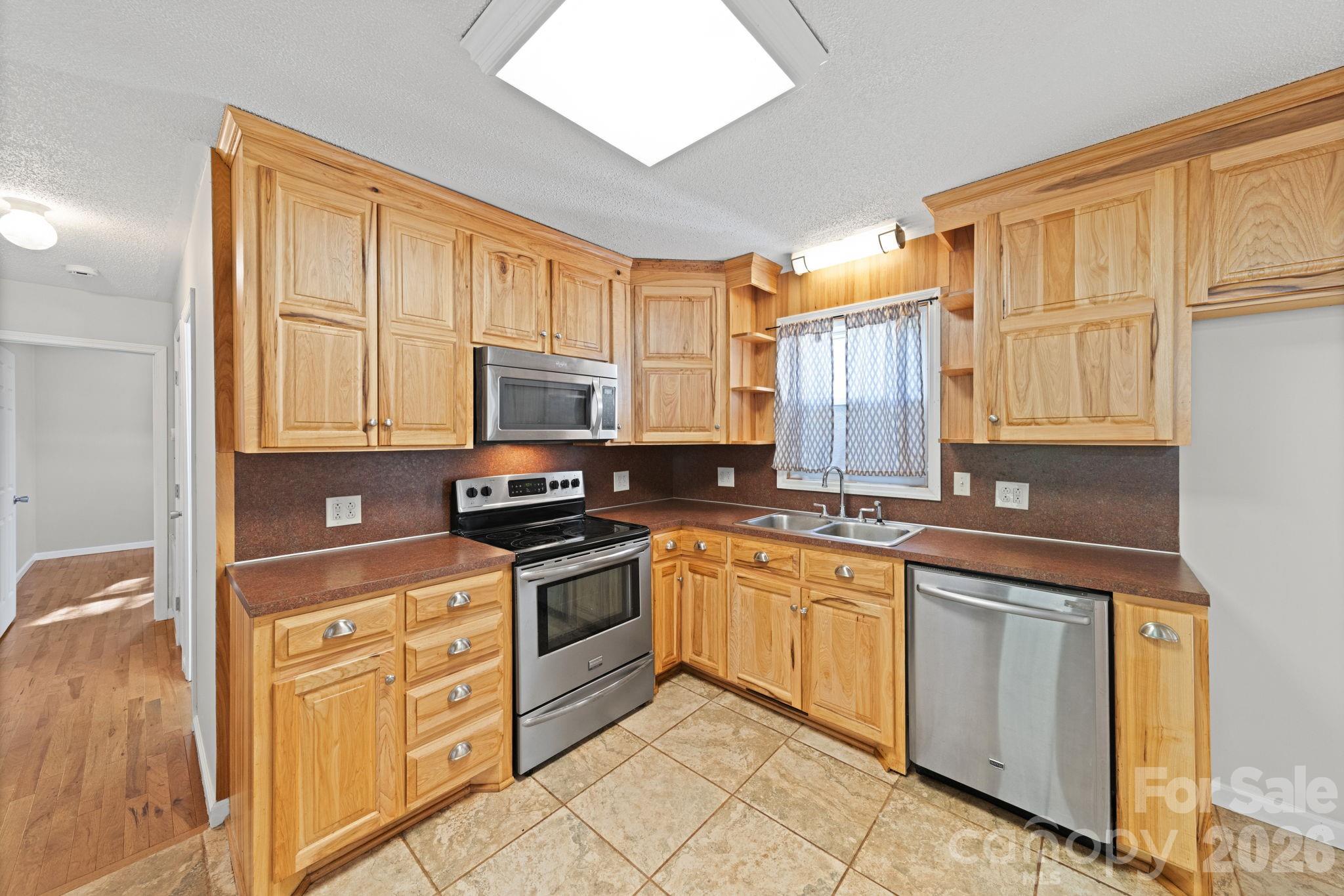 3227 Westover Road Statesville, NC 28677 - Photo 8 of 37 a kitchen with stainless steel appliances granite countertop a stove a sink and a microwave