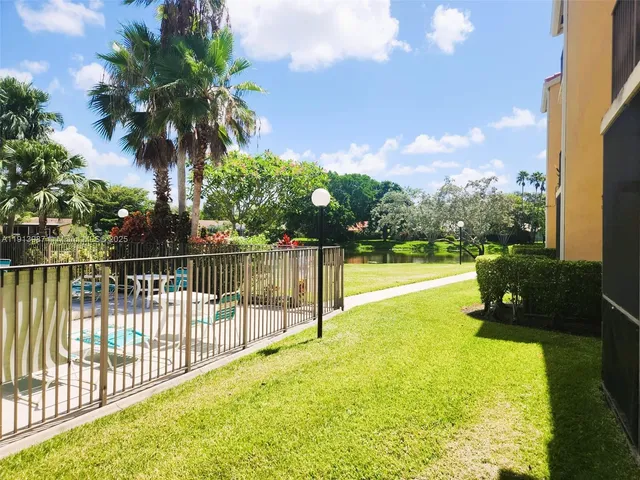 a view of a swimming pool with a garden and deck