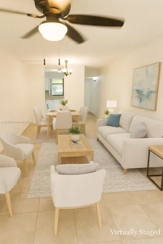 a living room with couches and kitchen view with wooden floor