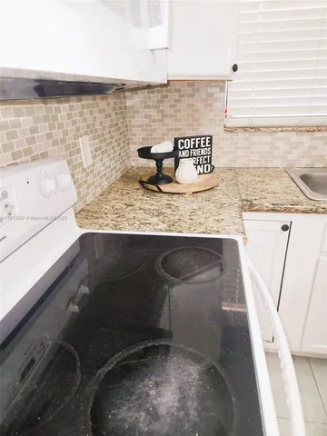 a bathroom with a granite countertop sink a toilet and mirror
