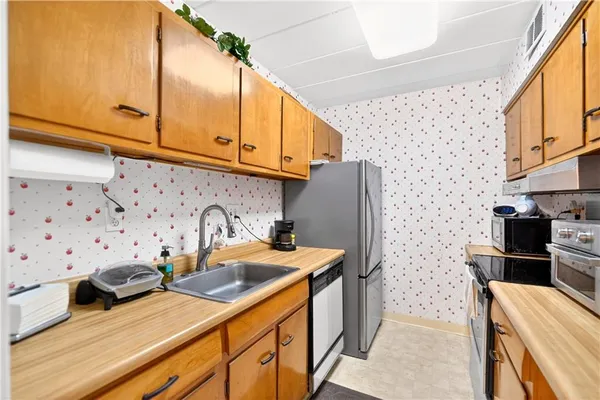 a kitchen with stainless steel appliances a stove a sink and a refrigerator
