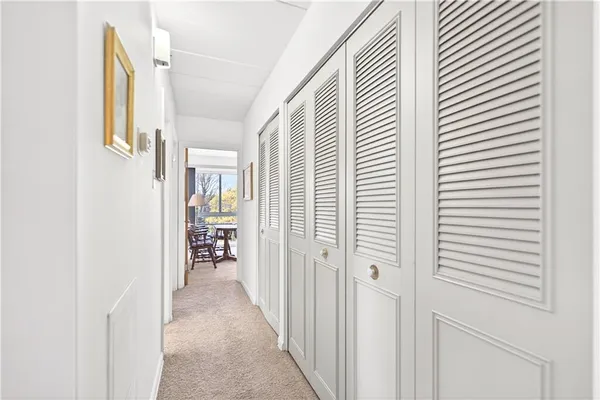 a view of a hallway with white walls and stairs