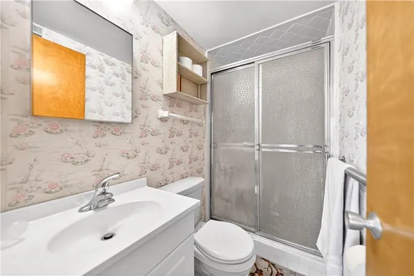 a bathroom with a sink mirror toilet and shower