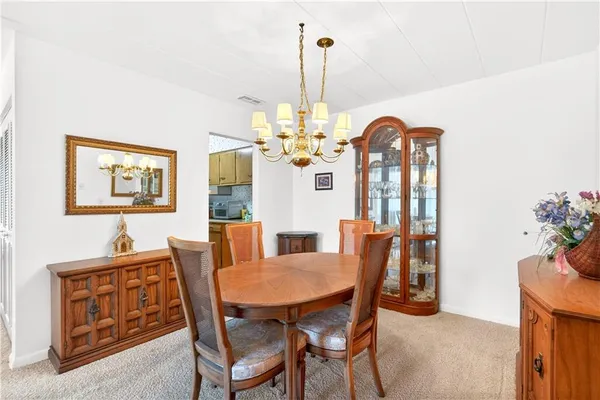 a dining room with furniture a chandelier and window