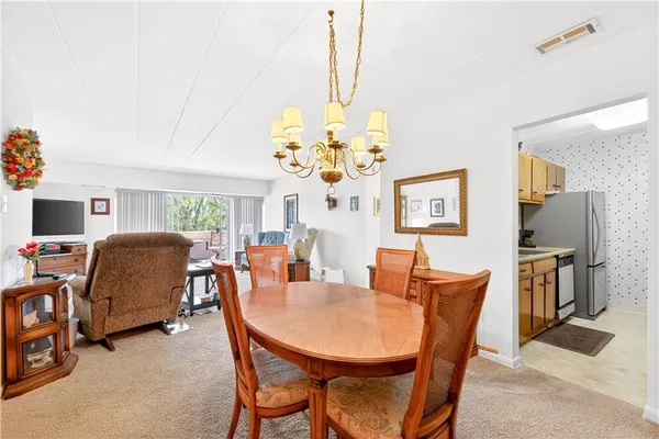 a view of a dining room with furniture and a chandelier