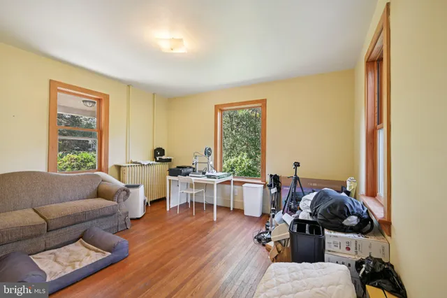 a view of a hallway with wooden floor and windows