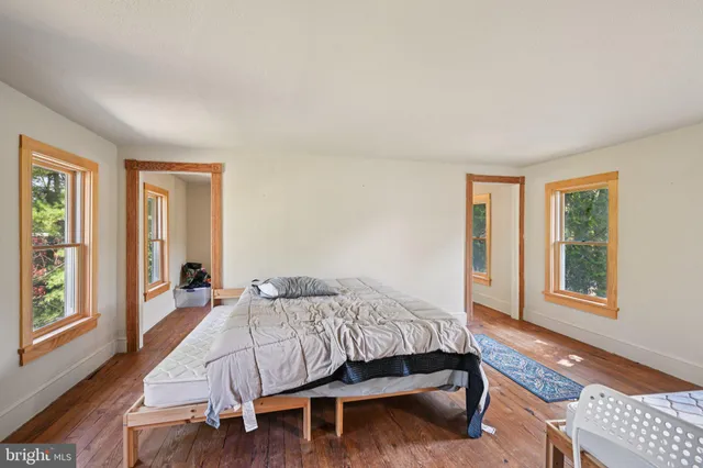 a bedroom with a bed and wooden floor